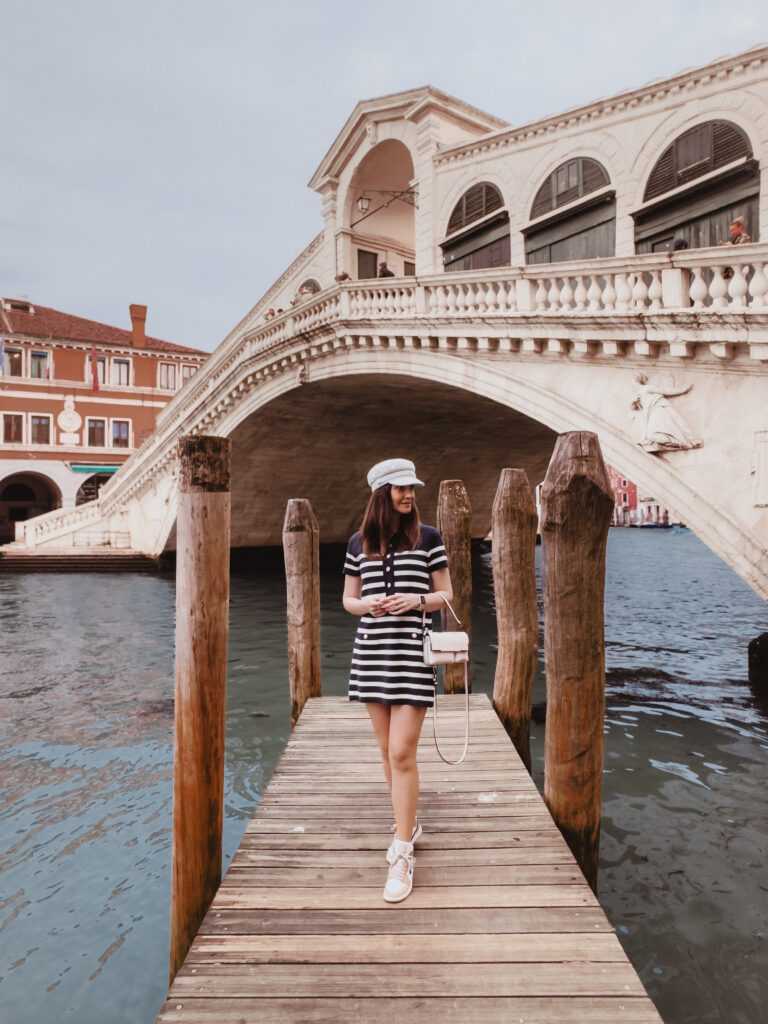 Woman standing with the Rialto Bridge in the background in Venice, Italy